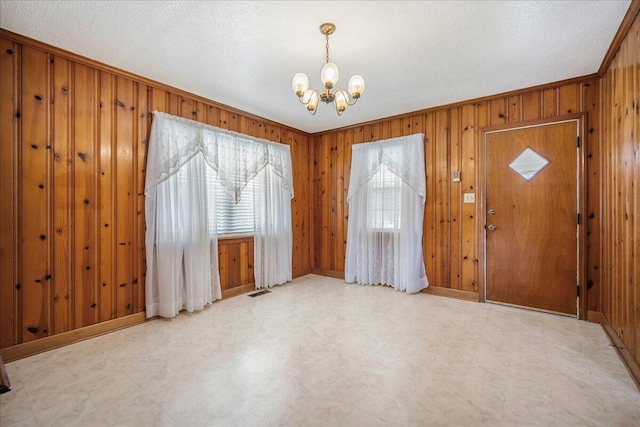 2830 Wire Rd, Saint George, SC 29477 - foyer featuring crown molding, wooden walls, a textured ceiling, and a chandelier