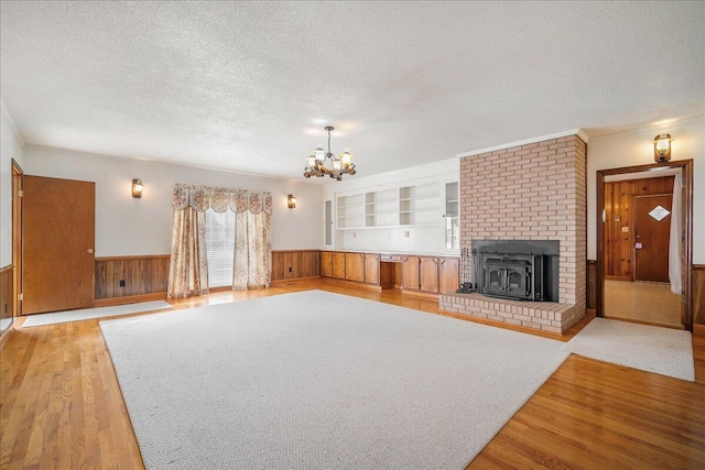 2830 Wire Rd, Saint George, SC 29477 - unfurnished living room featuring built in shelves, wooden walls, light hardwood / wood-style floors, and a textured ceiling