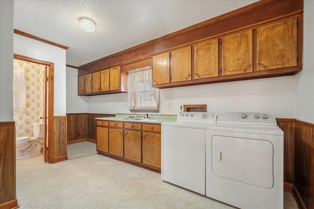 2830 Wire Rd, Saint George, SC 29477 - laundry area with washing machine and clothes dryer, sink, cabinets, a textured ceiling, and wooden walls