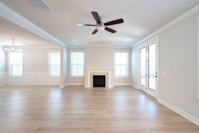 unfurnished living room with ceiling fan with notable chandelier, light hardwood / wood-style floors, and ornamental molding