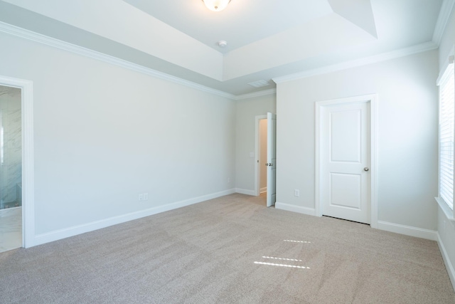 unfurnished bedroom with crown molding, light colored carpet, multiple windows, and ensuite bath