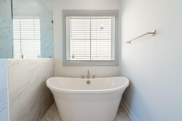 bathroom featuring tile walls and a tub