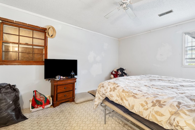 bedroom featuring crown molding, ceiling fan, and a textured ceiling