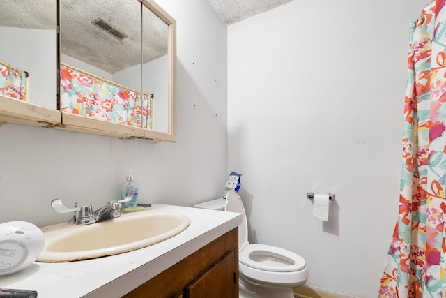 bathroom featuring vanity, toilet, and a textured ceiling