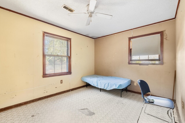 bedroom featuring a textured ceiling, ornamental molding, and ceiling fan