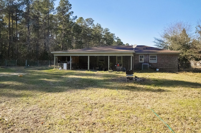 rear view of house featuring a yard