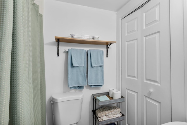 bathroom with a shower with shower curtain and toilet