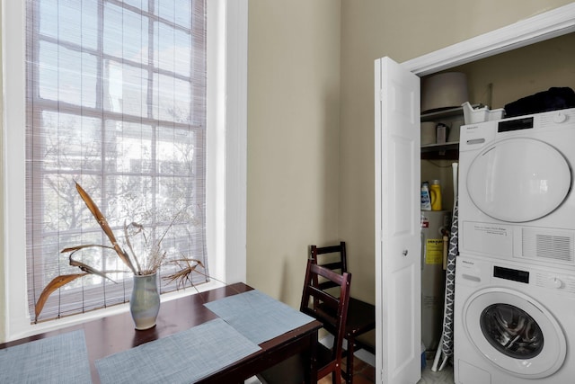 laundry room featuring stacked washer / dryer and electric water heater