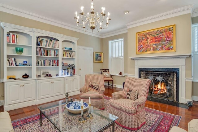 sitting room featuring ornamental molding, a notable chandelier, a premium fireplace, and dark wood-type flooring