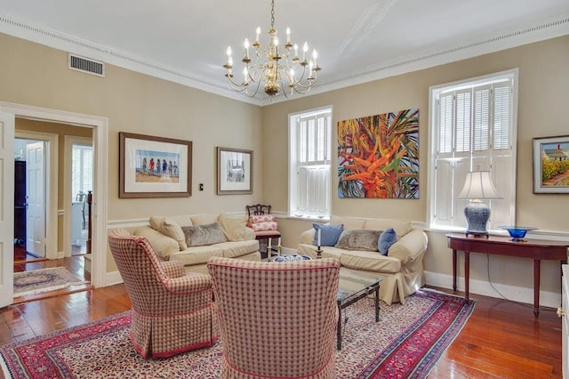 living room with wood-type flooring, an inviting chandelier, and ornamental molding