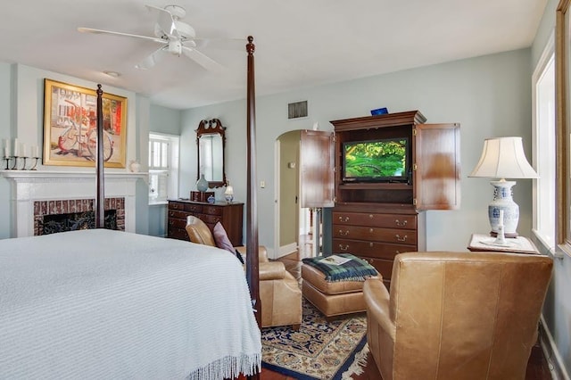 bedroom featuring ceiling fan, a fireplace, and a closet