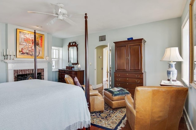 bedroom with a brick fireplace, ceiling fan, and a closet