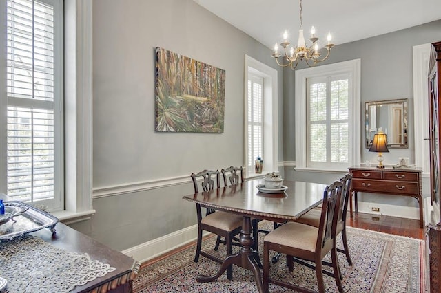 dining space with a notable chandelier and hardwood / wood-style floors