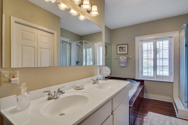 bathroom featuring hardwood / wood-style flooring, vanity, and shower with separate bathtub