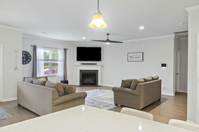 living room with wood-type flooring, ornamental molding, and ceiling fan