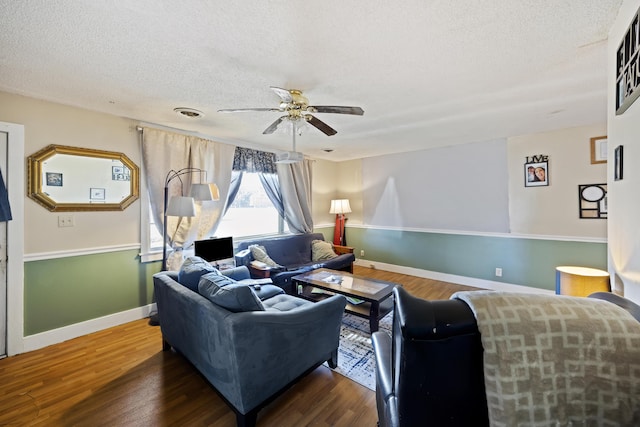 living room with a textured ceiling, dark hardwood / wood-style floors, and ceiling fan