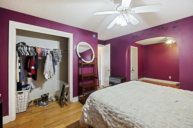 bedroom featuring ceiling fan, a closet, a textured ceiling, and hardwood / wood-style flooring