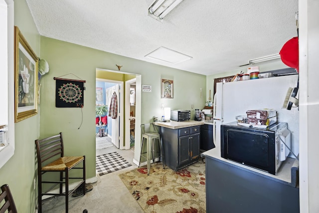 kitchen with a breakfast bar area and a textured ceiling