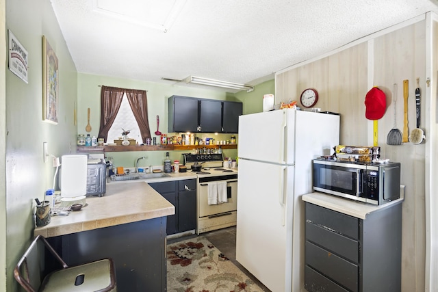 kitchen featuring a textured ceiling, white appliances, and sink