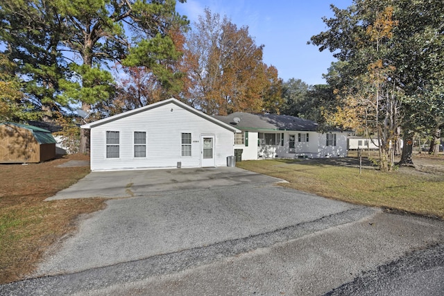 single story home with a storage shed and a front yard