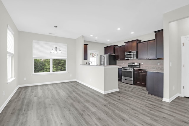 1510 Royal Colony Rd, Johns Island, SC 29455 - kitchen with stainless steel appliances, light countertops, light wood-style flooring, dark brown cabinets, and a chandelier
