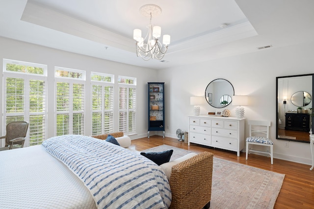 bedroom with baseboards, a chandelier, ornamental molding, and a raised ceiling