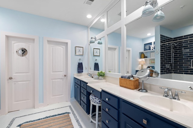 full bathroom featuring visible vents, a sink, double vanity, and a tile shower