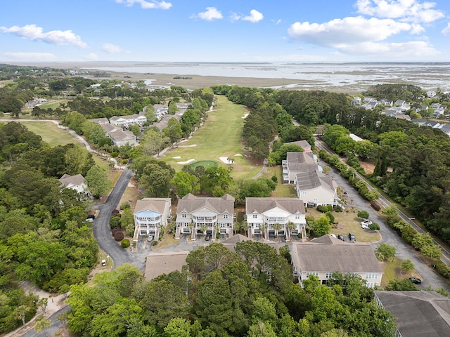 drone / aerial view with view of golf course and a water view