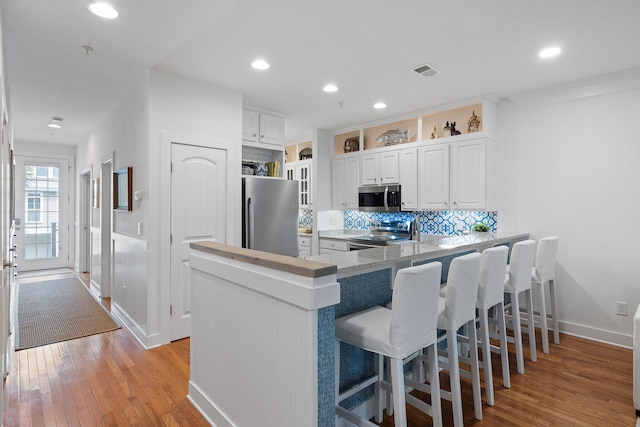 kitchen featuring visible vents, light wood-style flooring, baseboards, and stainless steel appliances