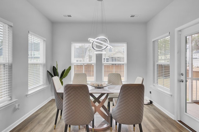 dining room with hardwood / wood-style floors and a chandelier