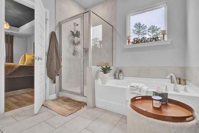 bathroom with tile patterned floors and shower with separate bathtub