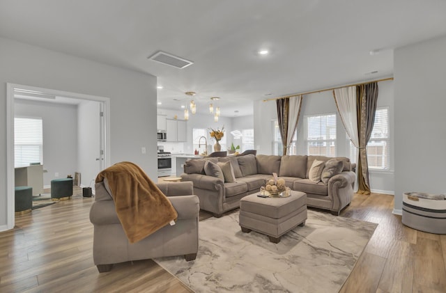 living room featuring sink and light hardwood / wood-style flooring