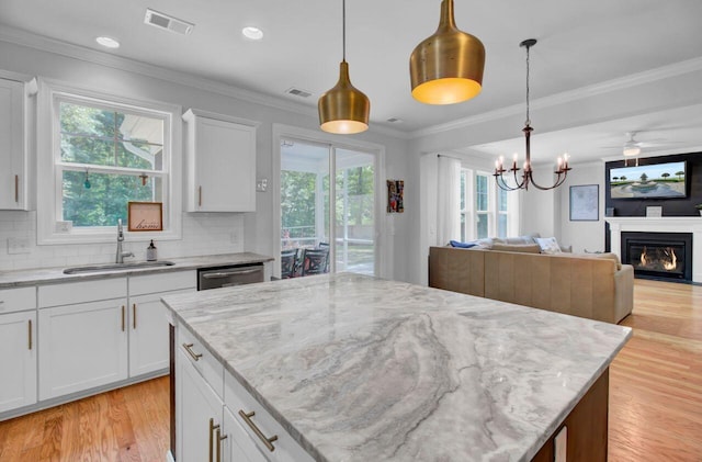 kitchen featuring white cabinetry, hanging light fixtures, and sink