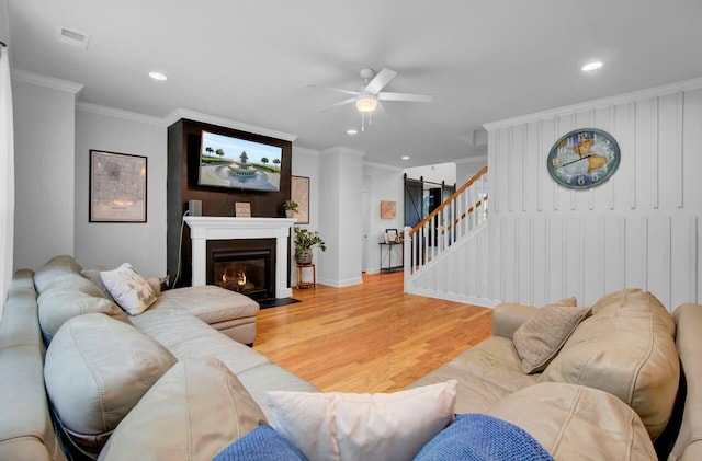 living room featuring crown molding, hardwood / wood-style floors, and ceiling fan