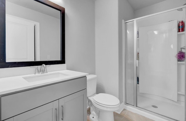 bathroom featuring tile patterned floors, vanity, toilet, and walk in shower