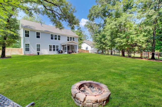 view of yard featuring a sunroom and a fire pit