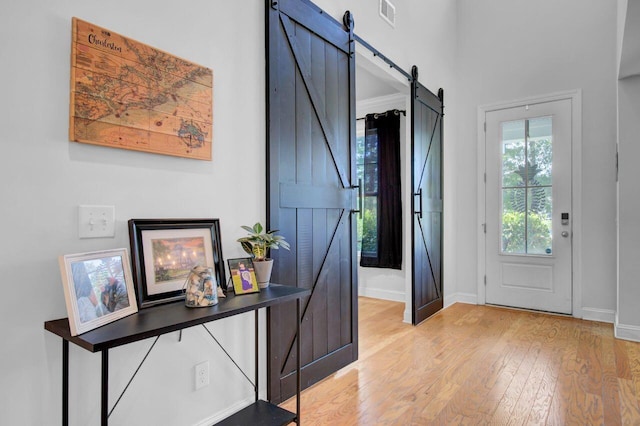 foyer entrance featuring a barn door and light wood-type flooring