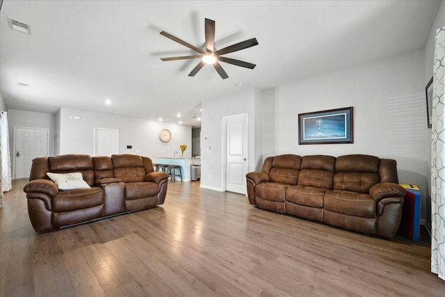 living room with ceiling fan and wood-type flooring