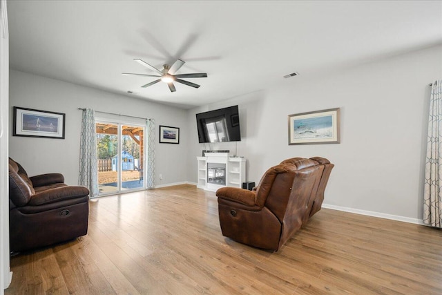 living room featuring ceiling fan and light hardwood / wood-style flooring