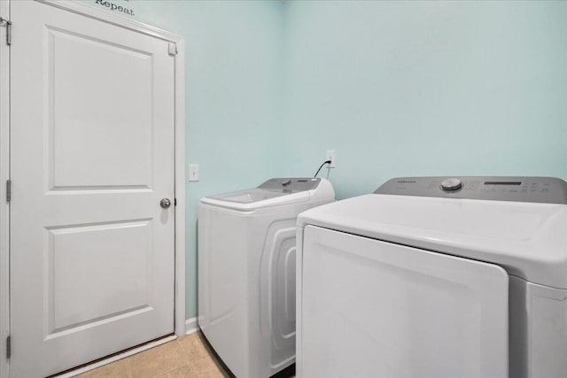 laundry area with light tile patterned flooring and washing machine and clothes dryer