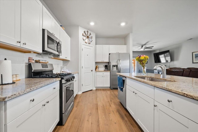 kitchen featuring stainless steel appliances, white cabinets, tasteful backsplash, and sink