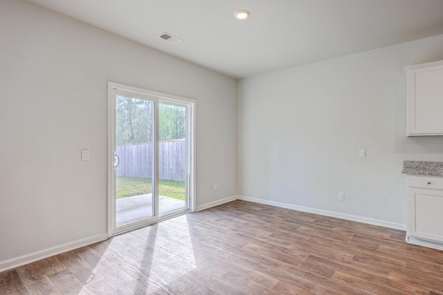 unfurnished dining area featuring wood finished floors and baseboards