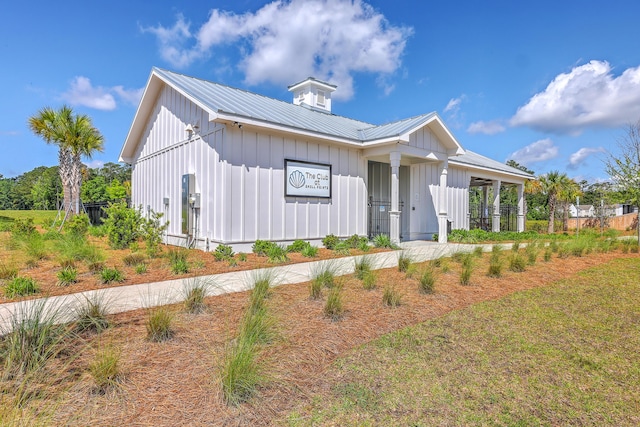 modern farmhouse featuring board and batten siding and metal roof