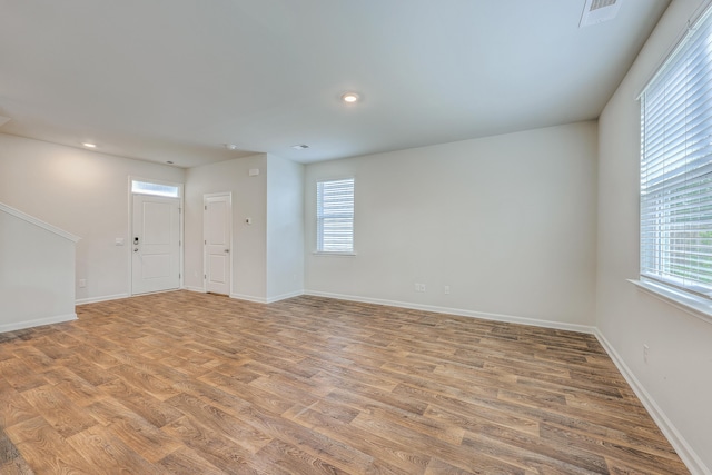 unfurnished room with light wood-type flooring, baseboards, and recessed lighting