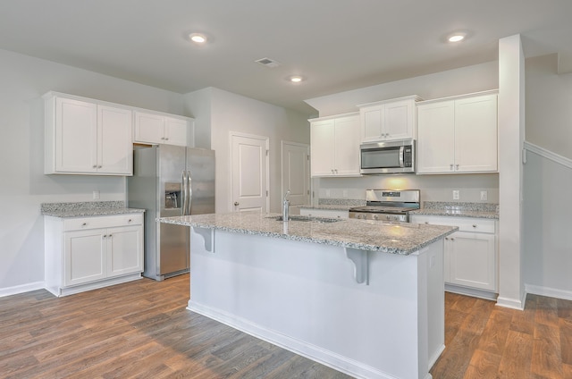 kitchen featuring stainless steel appliances, a sink, white cabinetry, and recessed lighting