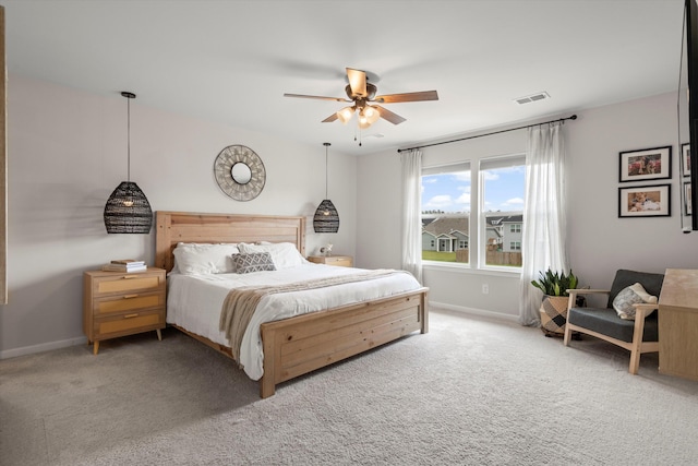 carpeted bedroom featuring baseboards, a ceiling fan, and visible vents