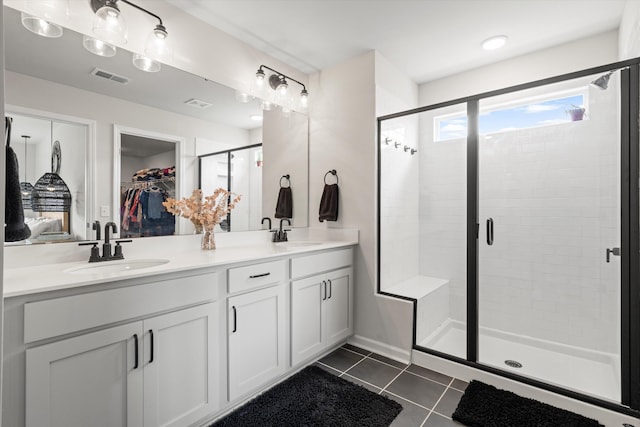 full bath with visible vents, a sink, tile patterned floors, and a shower stall