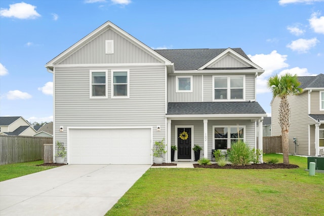 craftsman-style home featuring an attached garage, fence, a front yard, and concrete driveway