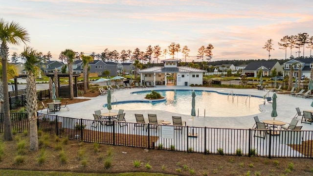 pool with fence, a patio area, and a residential view