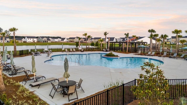 community pool featuring a patio area, fence, and a residential view